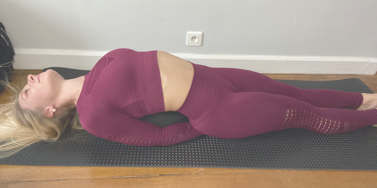 La photo décrit la posture de yoga du poisson.